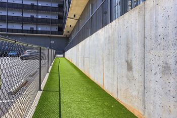 A long concrete wall with a green grassy area in the middle.
